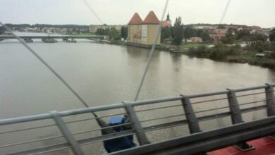 Most nad rzeką z widokiem na miasto i zabytkowy kościół, panorama miasta, most, architektura, Wisła, Polska, turystyka, widok z mostu, rekreacja, podróże, krajobraz miejski.