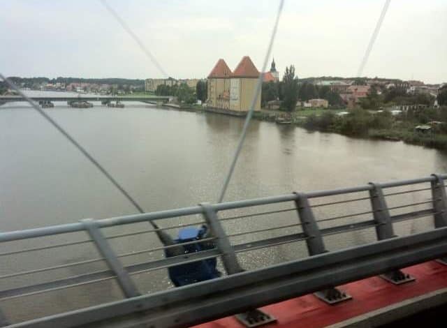 Most nad rzeką z widokiem na miasto i zabytkowy kościół, panorama miasta, most, architektura, Wisła, Polska, turystyka, widok z mostu, rekreacja, podróże, krajobraz miejski.