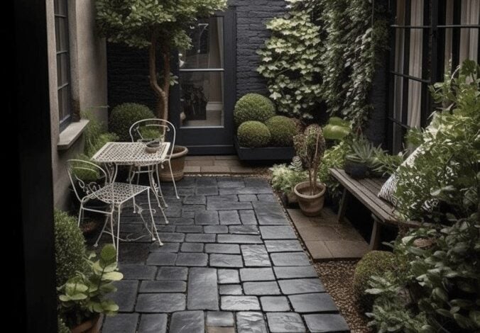 Czarna brukowa ścieżka w ogrodzie z zielonymi roślinami i meblami z metalu, nowoczesny ogród na patio w stylu skandynawskim, outdoorowe miejsce wypoczynkowe, aranżacja małej przestrzeni, elegancki ogród w centrum miasta.