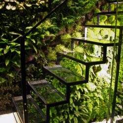 Rozwiązanie zielonej ścieżki z metalowymi stopniami i drzewa w tle, idealne dla nowoczesnych ogrodów i tarasów.