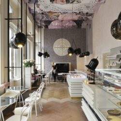 Przestronna kawalerka z nowoczesnym wystrojem, duże okna, eleganckie meble i wyeksponowane słodycze w witrynie, idealne miejsce do relaksu i spotkań w stylu optima.