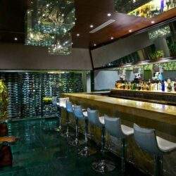 Nowy bar w eleganckim klimacie z komfortowymi krzesłami i różnorodnymi alkoholami, idealne miejsce na relaks i spotkania towarzyskie.