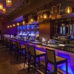 Elegancka restauracja z komfortowym barem i stylowym oświetleniem, idealna dla klientów szukających wysokiej jakości obsługi i wyjątkowej atmosfery.