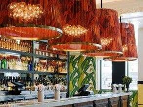 Elegancki barek restauracyjny z czerwonymi okrągłymi żyrandolami i nowoczesnym wystrojem wnętrza, idealny dla klientów poszukujących wyjątkowej atmosfery i wysokiej jakości usług.