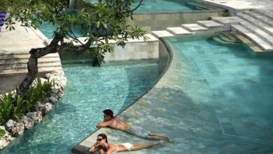 Relaks w basenie, luksusowy hotel, oaza spokoju, kąpiel w otoczeniu zieleni, komfortowe warunki, relaksacyjne miejsce, spa i wellness, wakacje marzeń, elegancki resort, odpoczynek na łonie natury.