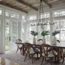 Nowoczesny elegancki stół jadalniany w jasnym, przestronnym pokoju z dużymi oknami i zieleń za oknem, idealny do aranżacji wnętrz zgodnych z optymalnym stylem.