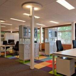Przestronne i nowoczesne biuro z podziałem na stanowiska pracy, dużymi oknami zapewniającymi naturalne światło i komfortowe warunki dla pracowników.