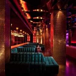 Podświetlony klub nocny z luksusowymi sofami i efektownym oświetleniem, idealny na wyjątkowe wydarzenia i spotkania w eleganckim otoczeniu.