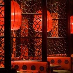 Klimatyczne czerwone lampiony w restauracji z stylowym wystrojem, tworzą elegancką atmosferę sprzyjającą relaksowi i spotkaniom biznesowym.