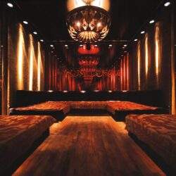 Elegancka sala bankietowa z ciepłym oświetleniem i luksusową aranżacją wnętrza.