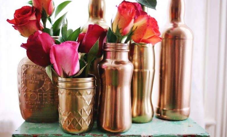 Róże w dekoracyjnych złotych wazonach na rustykalnym stole, elegancka aranżacja kwiatowa do wnętrz, stylowa dekoracja na różne okazje, luksusowe dodatki do domu.