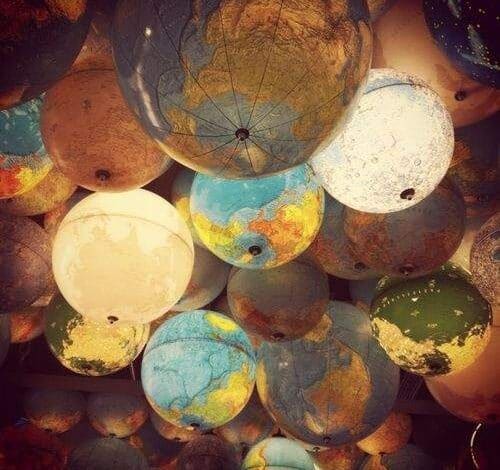 Globus ziemi na tle innych gymbalow, wizualizacja edukacyjna i geograficzna, inspiracja do nauki o świecie, ukazanie różnorodności kontynentów i kultur, sklep edukacyjny, materiały do nauki geografii dla dzieci i młodzieży.