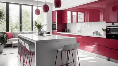 Nowoczesna kuchnia z czerwonymi frontami i białym wyspą, jasne wnętrze, duże okna zapewniają naturalne światło, stylowe oświetlenie i nowoczesny design, optymalna przestrzeń do gotowania i spędzania czasu.