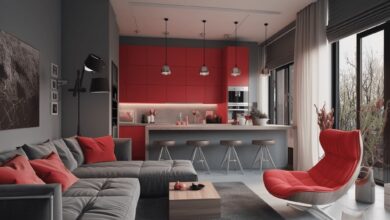 Nowoczesny salon z kuchnią w stylu skandynawskim, minimalistyczne wnętrze z czerwonymi akcentami, dużymi oknami i wygodnymi meblami, idealne do relaksu i spotkań rodzinnych.