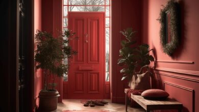 Przedpokój w eleganckim czerwonym kolorze z naturalnym światłem, pamiątkami, i roślinami, w stylu klasycznym. Idealne miejsce na pierwsze wrażenie w luksusowym domu lub apartamencie.