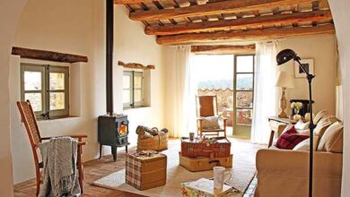 Komfortowy salon z drewnianym sufitem, stylowym kominkiem i przytulnym wystrojem, idealny na relaks i odpoczynek w domu lub wynajmie krótkoterminowym na optymalnym poziomie jakości.