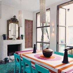 Kolorowa jadalnia z dużymi oknami, stylowe lampy i dekoracje, unikalny wystrój wnętrza z nowoczesnym akcentem, idealne miejsce do spotkań i relaksu, inspirujące dla miłośników designu.