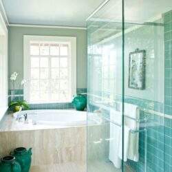 Naturalny widok łazienki z dużym oknem i akcentami zieleni, nowoczesna kabina prysznicowa z szybą, elegancka przestrzeń relaksacyjna, aranżacja w pastelowych odcieniach, komfort i styl w Twojej łazience.