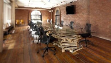 Nowe, eleganckie biuro z dużym stołem konferencyjnym i wygodnymi krzesłami w klimatycznym wnętrzu z ceglaną ścianą. Idealne miejsce na spotkania biznesowe i współpracę.