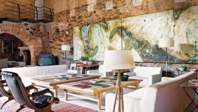 Nowoczesny salon z industrialnym klimatem, designerskie meble i sztuka na ścianie, wnętrze z dużymi oknami i ceglaną ścianą, idealne do pracy i relaksu, PaniDyrektor.pl.