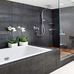 Ekspresowa kąpiel w nowoczesnej jacuzzi z hydromasażem, eleganckie wykończenie łazienki z czarnymi płytkami, relaks w luksusowym otoczeniu.