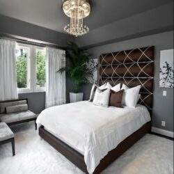 Przytulna sypialnia z nowoczesnym wystrojem, eleganckim łóżkiem i dużym oknem zapewniającym naturalne światło. Idealne miejsce do relaksu i odpoczynku w stylowym wnętrzu.