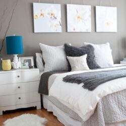 Stylowe, nowoczesne łóżko w sypialni z dekoracyjnymi poduszkami i eleganckimi obrazami na ścianie. Idealne aranżacje wnętrz dla komfortu i relaksu.