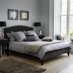 Przytulna sypialnia z dużym łóżkiem, nowoczesny wystrój, naturalne światło, eleganckie dodatki, idealna do relaksu i odpoczynku.