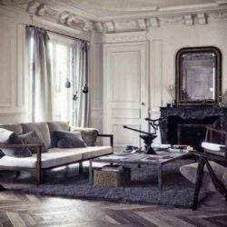 Nowoczesne wnętrze salonu w klasycznym stylu, elegancka aranżacja z dużym wypoczynkiem, kominkiem i stylowymi dodatkami, idealne dla miłośników luksusowych przestrzeni.