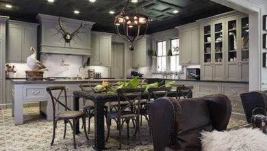 Nowoczesna kuchnia w stylu skandynawskim z białymi szafkami i drewnianym stołem, elegancka i funkcjonalna przestrzeń do codziennych posiłków.