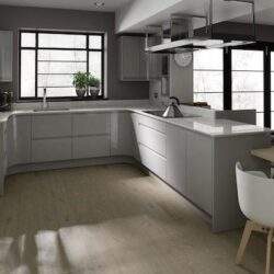 Nowoczesna kuchnia w minimalistycznym stylu z dużymi oknami i jasnymi meblami, idealna do funkcjonalnego i eleganckiego wnętrza, sprzyja komfortowi codziennego gotowania i spotkań rodzinnych.