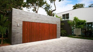 Automatyczna brama garażowa z drewna i cegły, nowoczesny design, estetyczne wykończenie, idealne do domów jednorodzinnych, funkcjonalne rozwiązanie dla bezpieczeństwa i wygody.