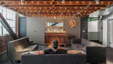 Relaksująca przestrzeń w nowoczesnym biurze z wygodnymi sofami i unikalnym designem, idealna do odpoczynku i networking'u w otoczeniu ciepłego oświetlenia i eleganckiego wystroju.