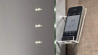 Ekran z telefonem i odtwarzaczem muzyki zamontowany w ścianie na eleganckiej półce, nowoczesny gadżet do słuchania muzyki, technologia audio, wyposażenie wnętrz, smart home, PaniDyrektor.pl.