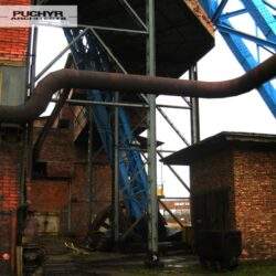 Ruiny przemysłowe, stalowa konstrukcja i ceglane budynki, industrialny krajobraz, zniszczony obiekt przemysłowy, czysto techniczne elementy, przemysłowa architektura, zniszczone fabryki, przemysłowe残存 fundamento, industrialny pejzaż, PaniDyrektor.pl.