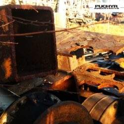 Metalowe elementy stalowe zniszczone i postrzępione, przemysłowe odpady na złomowisku, elementy konstrukcji stalowej, zardzewiałe fragmenty metalu, surowe materiały metalowe do recyklingu.