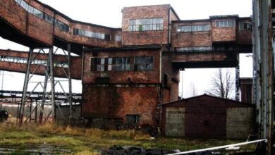 Opuszczona, zniszczona fabryka z czerwonej cegły na zewnątrz, fragment budynku z przemysłowym charakterem, idealna do fotografii krajobrazowej i urban exploration.