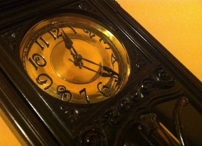 Wygląd starego zegara na ścianie, stylowy antyczny zegar dębowy, elegancki mebel z zaaranżowanego wnętrza, idealny dla miłośników klasycznego designu i historycznego klimatu.