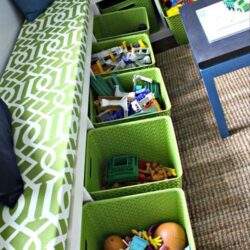 Lepiej zorganizowane zabawki dziecięce w zielonych pudełkach pod łóżkiem w pokoju dziecięcym.