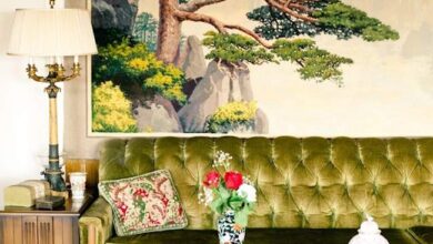 Przytulny pokój z zieloną sofą i japońskim drzewem na obrazie, eleganckie dodatki, lampka, rośliny, dekoracje, styl skandynawski i orientalny, idealny do relaksu i pracy.