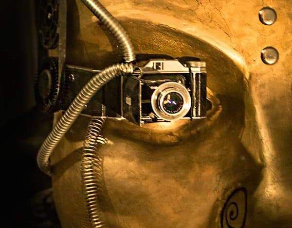 Lustrzana fotografia ukrytą kamerę w złoconej maseczce artystycznej, nowoczesna technologia i sztuka, związane z kreatywnością i innowacją, inspirujący wizualny przekaz.