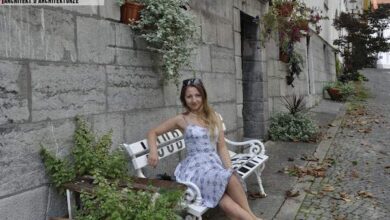 Relaksująca kobieta na ławce w historicznej okolicy, z roślinami i kwiatami, atrakcje architektoniczne, spacer, piękny pejzaż, atmosfera odpoczynku, styl miejski, natura i architektura, relaks na świeżym powietrzu.