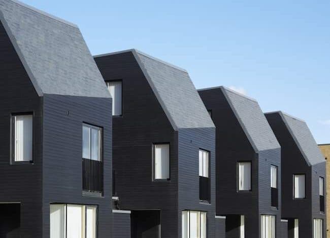 Nowoczesne domy jednorodzinne z czarną elewacją i stromymi dachami, wysokiej jakości architektura, idealne rozwiązanie dla poszukujących innowacyjnego designu i funkcjonalności.