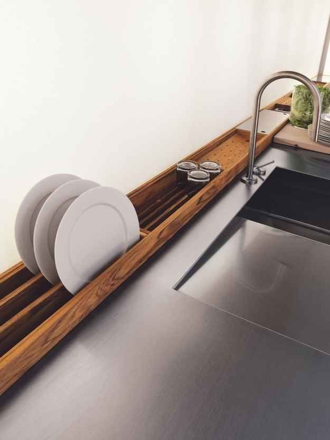 Ciekawy i designerski przykład na umieszczenie ociekarki na naczynia. Drewniany ociekacz zajmuje miejsce wzdłuż blatu, którego i tak nie wykorzystujesz.