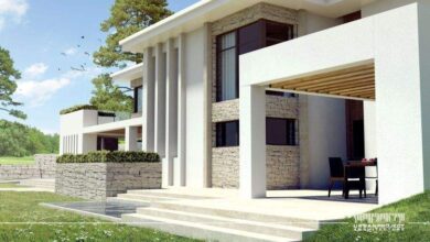 Nowy nowoczesny dom z dużymi przeszkleniami i minimalistycznym designem, otoczony zielenią, idealny dla miłośników architektury i komfortowych rozwiązań mieszkaniowych.