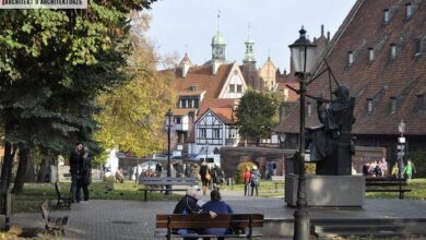 Oaza spokoju w sercu miasta, z tradycyjnymi kamienicami i pomnikiem, idealne miejsce na relaks i spotkania, widok na zabytkowe budowle i spokojną atmosferę w centrum.