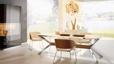 Nowoczesna jasna jadalnia z dużymi oknami i eleganckim stołem, idealne miejsce do spotkań i pracy w inspirującym otoczeniu.