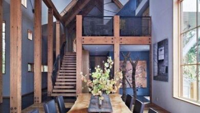 Nowoczesny jadalnia w drewnianym stylu z dużymi oknami, eleganckim stołem i monochromatycznymi krzesłami, idealne do aranżacji wnętrz optymalnych.