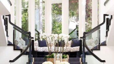 Przytulny hol z dużymi oknami i elegancką sofą, idealny do relaksu, z naturalnym światłem i dekoracyjnymi elementami, tworzący komfortowe wrażenie w domu.