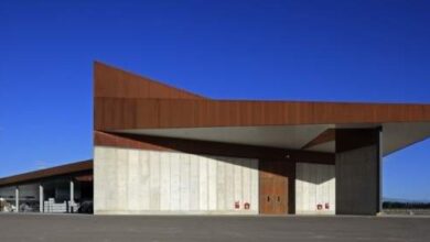 Nowy nowoczesny terminal lotniczy z minimalistyczną architekturą, drewnianymi elementami i dużą przestrzenią w otoczeniu nieba, idealny dla optymalnej obsługi pasażerów i podróżnych.